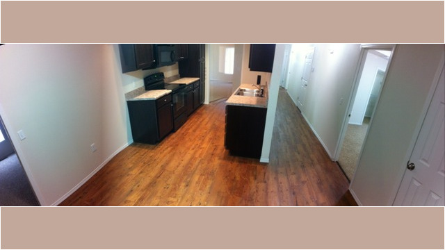 Kitchen includes stove, refrigerator, dishwasher, and microwave, with wood-grain vinyl flooring Kitchen