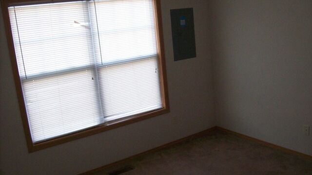The carpeted front bedroom has a huge window. Front bedroom